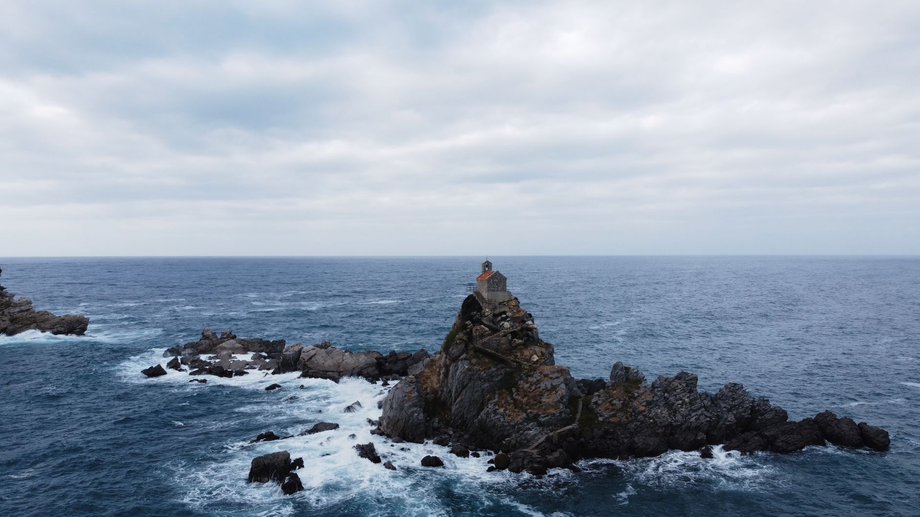 Aerial view of the iconic church on a rocky outcrop in Petrovac, Montenegro.