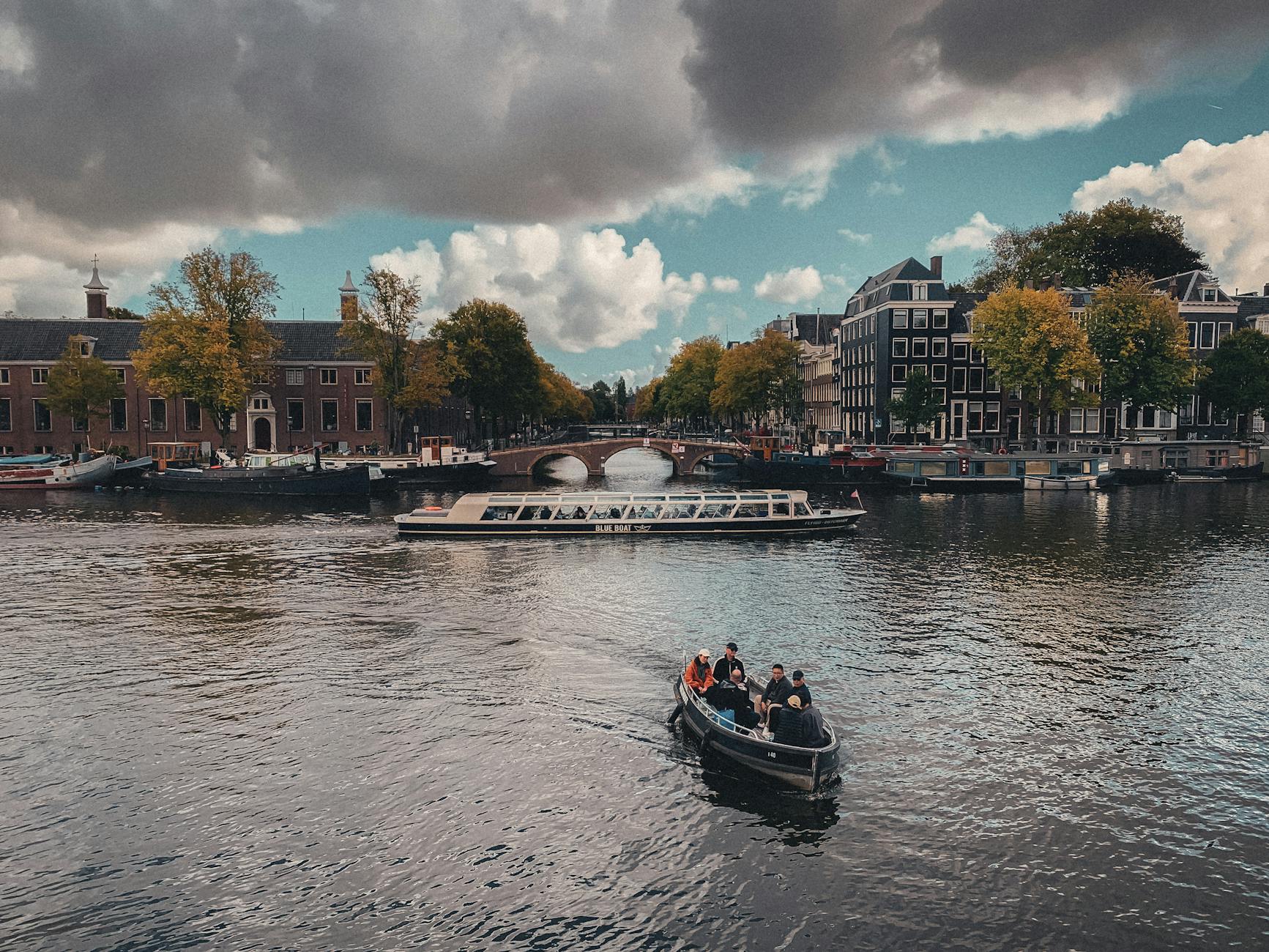 Picturesque canal view with boats and historic buildings in Amsterdam, Netherlands.