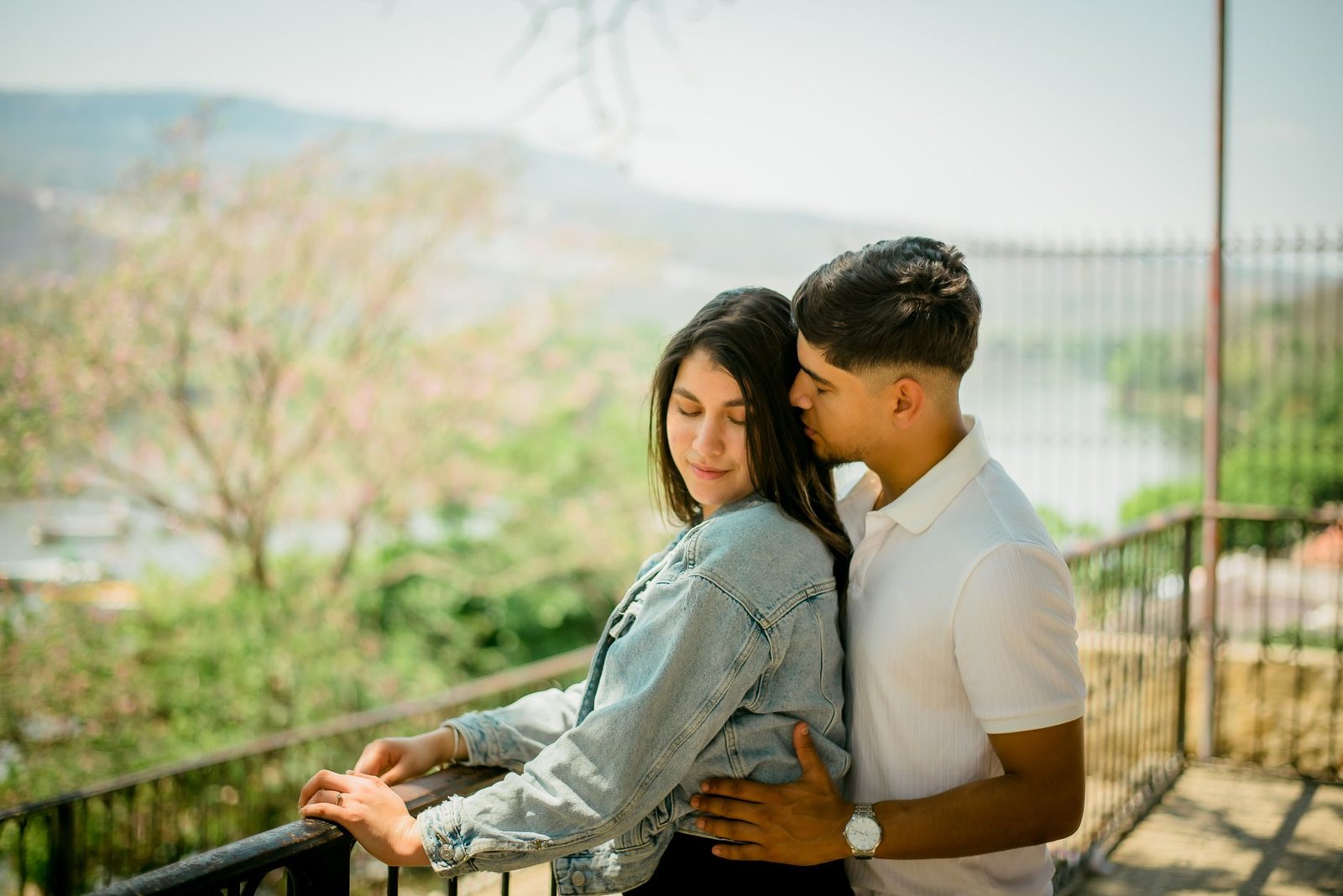 Tender moment captured between a young couple embracing outdoors, full of affection and love.